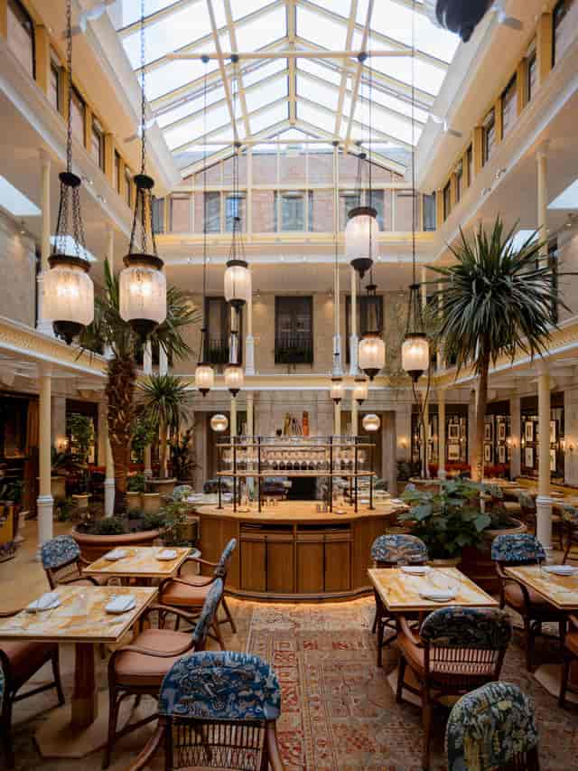 Elegant event space with vibrant atrium and greenery, ideal for networking or gatherings.