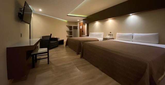 Double-occupancy hotel room with workspace for conference accommodation.