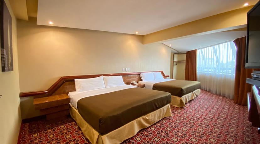 Double-queen hotel room at Escala Central del Norte for budget group travel events.