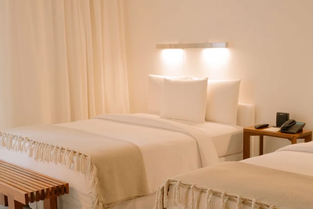 Double-occupancy hotel room with neutral decor for conference room blocks and business events.