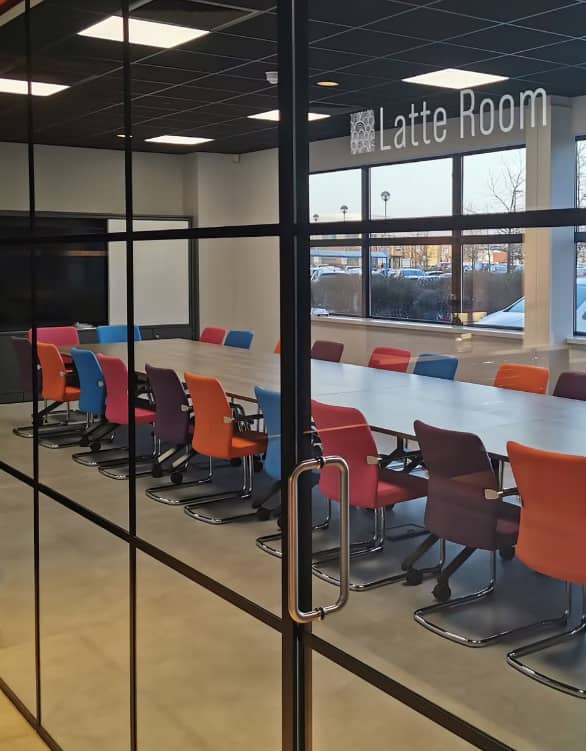 Modern meeting room at Highfield Coffee Social with glass walls for collaboration.
