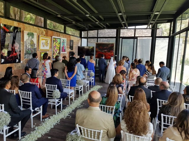 Wedding ceremony in Vinícola del Bosque art gallery with glass walls for intimate events.