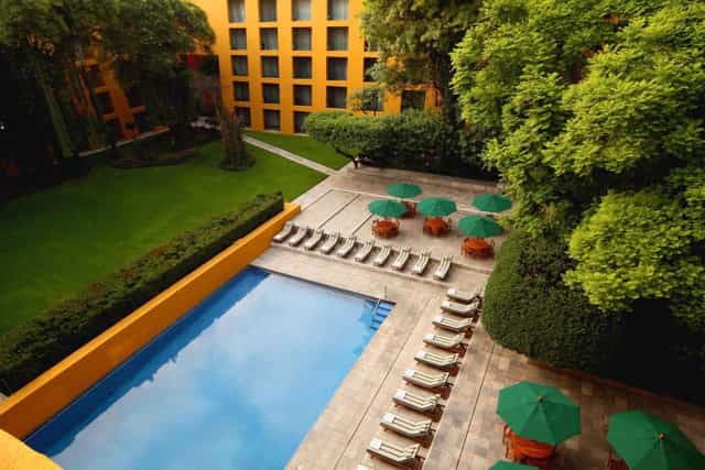 Outdoor swimming pool and lounge area at Camino Real Polanco for corporate events and networking.