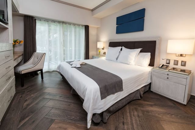 Modern hotel suite with desk for business travel and corporate event room blocks.