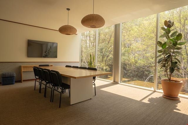 Minimalist meeting room with natural light for collaborative breakout sessions and corporate events.