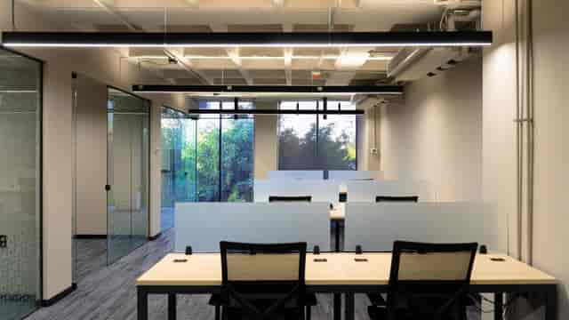 Modern private office at Workrooms Rio Mixcoac with minimalist desks for coworking and remote teams.