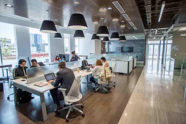 Modern open-plan IVO ROOM at IOS Offices with privacy screens for agile coworking and team meetings.