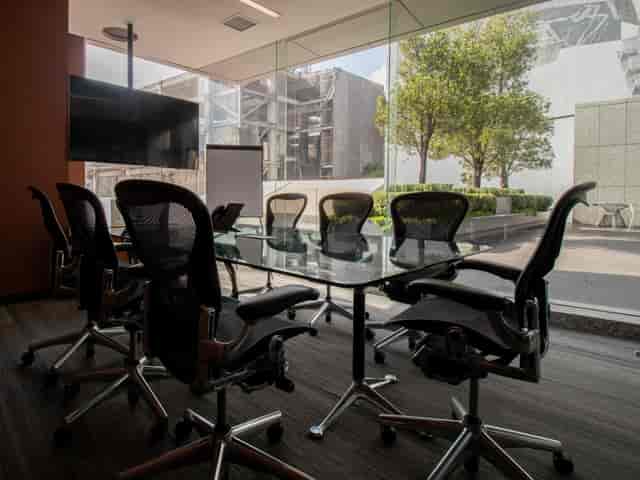 Modern boardroom with glass walls and ergonomic seating for executive strategy sessions.