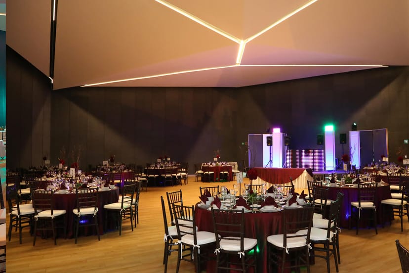 Modern ballroom with dark linens and LED lighting for corporate events and gala banquets.