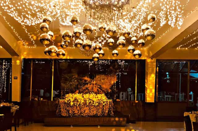 Salón Candiles gala venue with clustered disco ball and fairy light ceiling installation.