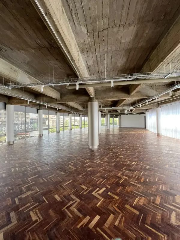 Industrial-chic event hall with parquet floors for networking receptions and pop-ups.