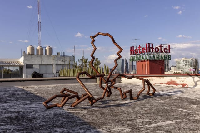 Industrial rooftop gallery venue with sculptural art for edgy experiential corporate events.