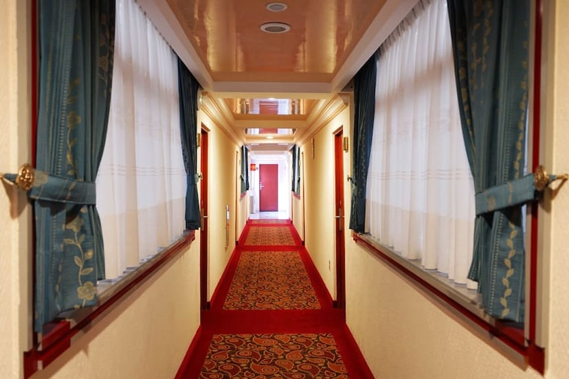 Dated hotel hallway in Hotel Mónaco CDMX showing poor lighting and narrow layout for event planning.