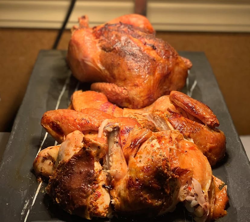 Rustic buffet with roasted chicken on a slate platter for corporate lunch or harvest dinner.
