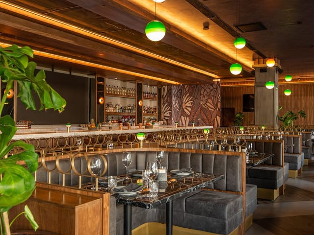 Sophisticated restaurant with tiered booth seating for corporate dinners and networking events.