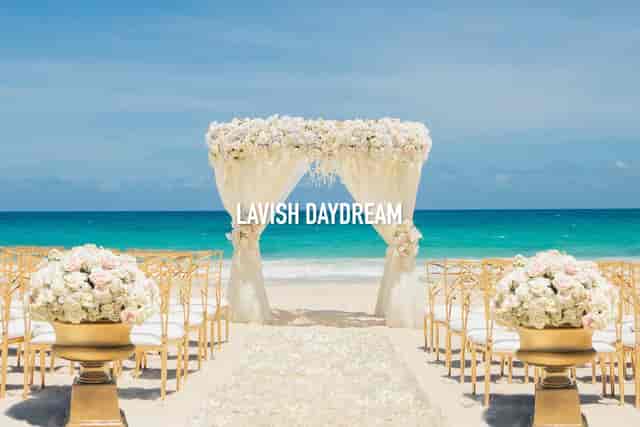 Beachfront wedding at Fania Ballroom, Hard Rock Riviera Maya with elegant floral arch and gold decor.