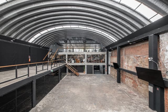 Industrial-chic Salón Principal at Lucerna 32 featuring vaulted ceilings for experiential events.