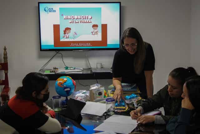 Small-group hybrid workshop at Casa Gallina education center with interactive glass-top table.
