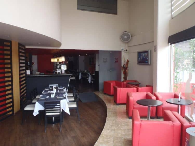 Hotel Tlahuac restaurant with red-accented lounge for business meetings and networking events.
