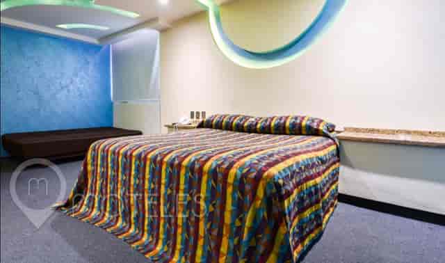 Hotel Siesta del Sur triple room with outdated decor for corporate and event housing.