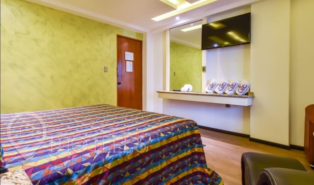 Dated Motel Siesta del Sur guest room with patterned bedding for budget travel or events.