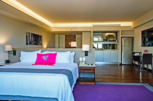 Modern junior suite with kitchenette and workspace for VIP and business travel.