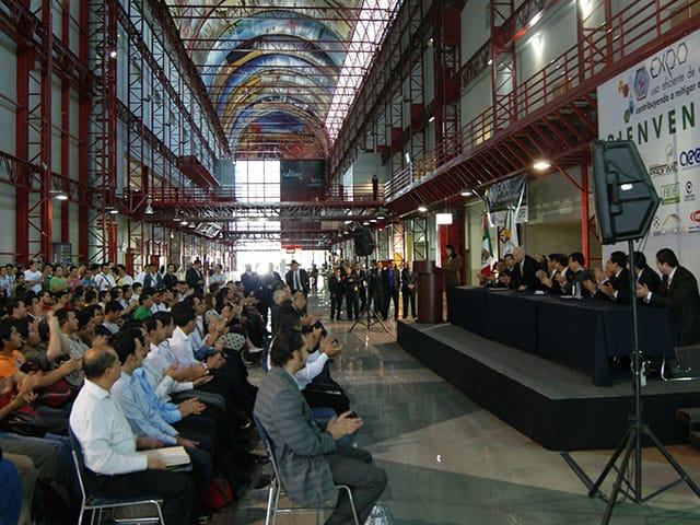 VIP Area industrial venue with stage for keynote session and theater-style corporate event seating.