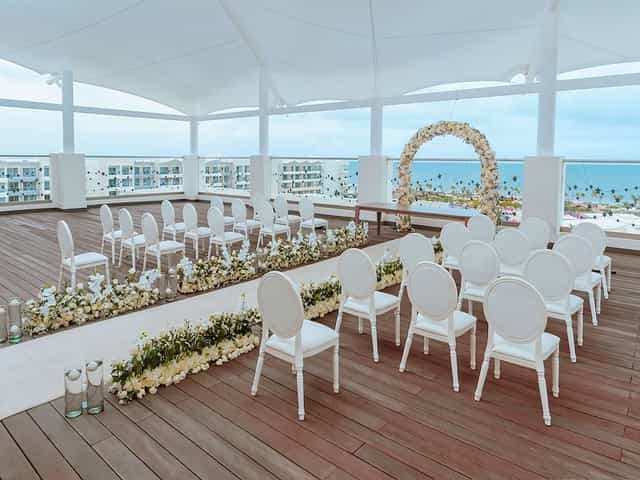 Open-air oceanfront wedding venue with white Chiavari chairs for destination ceremonies.