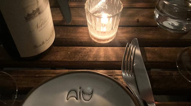 Rustic wine bar table setting with warm candlelight for VIP corporate networking dinner.