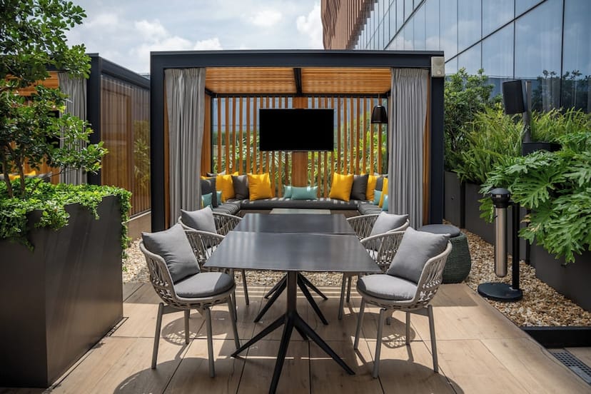 Gran Premio open-air breakout space with lush greenery for corporate networking and team meetings.
