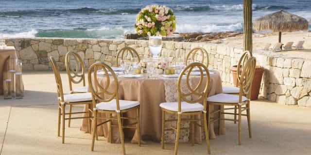 Grand Fiesta Americana ballroom with gold chairs and floral centerpiece for luxury weddings, galas.