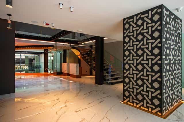 Contemporary pre-function foyer with geometric wall for luxury networking and guest registration.