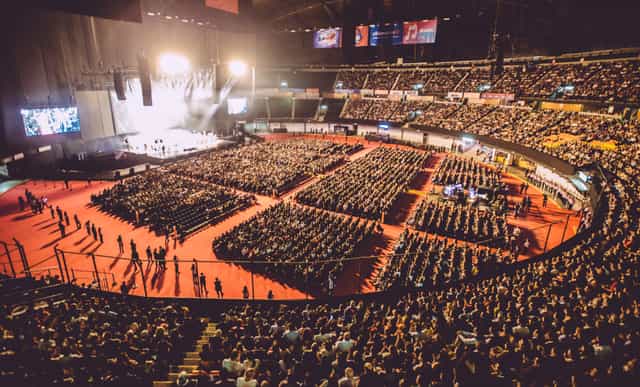 Palacio de los Deportes auditorium with proscenium stage for large-scale corporate events.