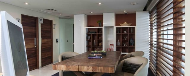 Rustic wooden boardroom table in a sophisticated, private meeting room for executive discussions.