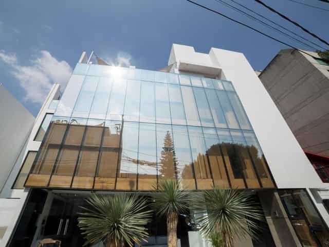Modern glass-fronted venue at Suites Arboleda 215 for corporate mixers and private showcases.