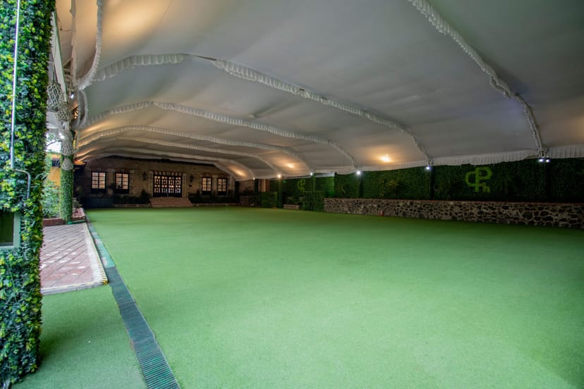 Patio Pirul outdoor event venue with tension tent and stone wall for corporate or social events.