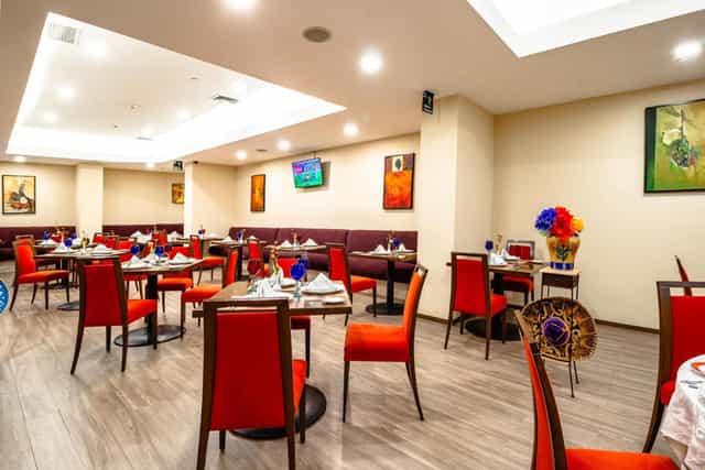 Red chairs in a Camino Real Aeropuerto banquet hall for corporate events and private dining.