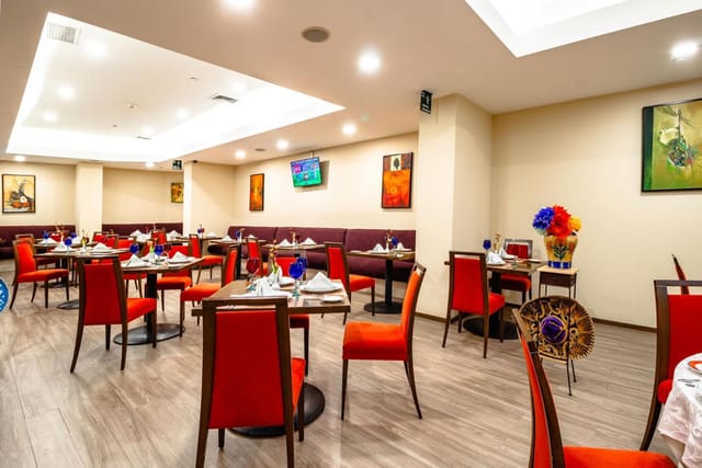 Red chairs in a Camino Real Aeropuerto banquet hall for corporate events and private dining.