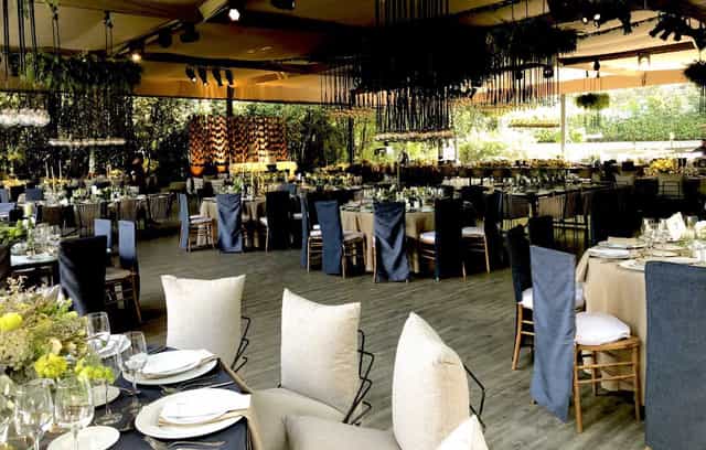 Elegant tented venue with industrial-chic ceiling decor for sophisticated weddings and galas.