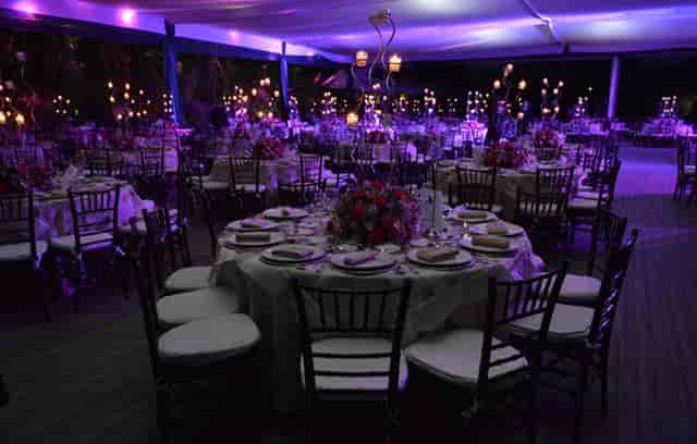Purple-lit gala at Salones Jardín Lomas Altas with elegant round table seating for event venue.