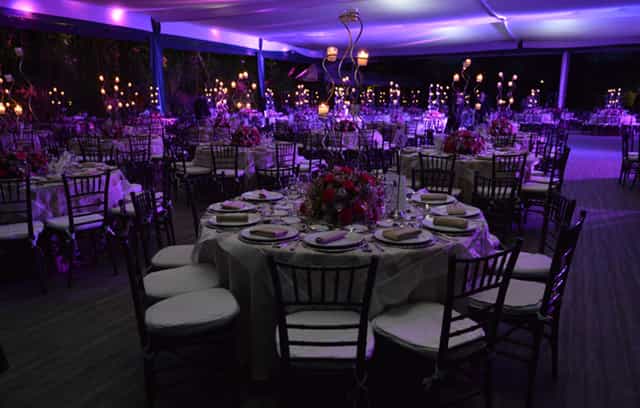 Purple-lit gala at Salones Jardín Lomas Altas with elegant round table seating for event venue.