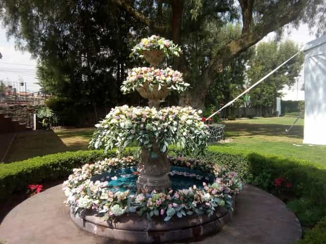 Floral tiered fountain installation at Hacienda la Esmeralda outdoor garden wedding event.