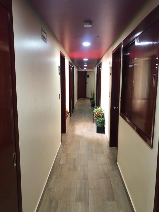 Dated hotel corridor at Hotel Jard Inn, featuring narrow hallways for event logistics.