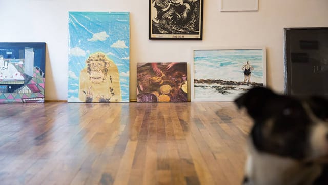 Unprofessional art gallery display at Casa Equis event space featuring floor-leaning canvases.