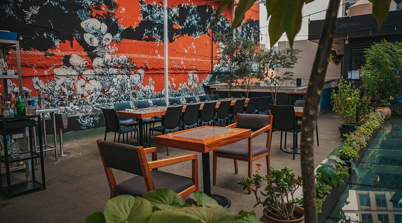 Networking event at Alelí Rooftop with vibrant mural wall and flexible outdoor seating.