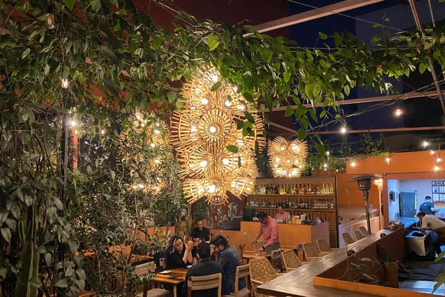 Alelí Rooftop event space with warm ambient lighting for evening receptions and networking mixers.