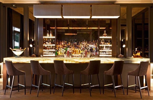 Upscale backlit stone bar at Café Beau-Rivage, perfect for VIP networking and corporate receptions.