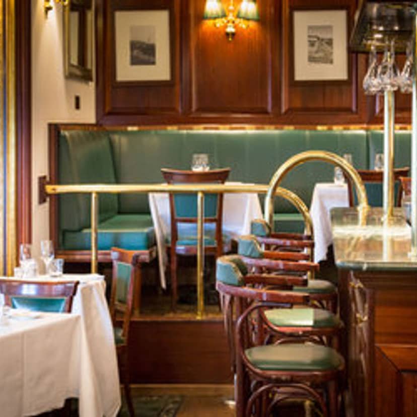 Elegant tiered brasserie dining room with banquette seating for corporate events and meetings.