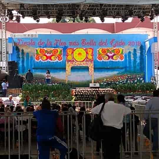 Floral-decorated stage at Plaza Central Xochimilco for cultural event and festival production.