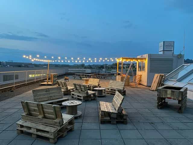 Rooftop restaurant with string lights, industrial-chic event space for casual parties.